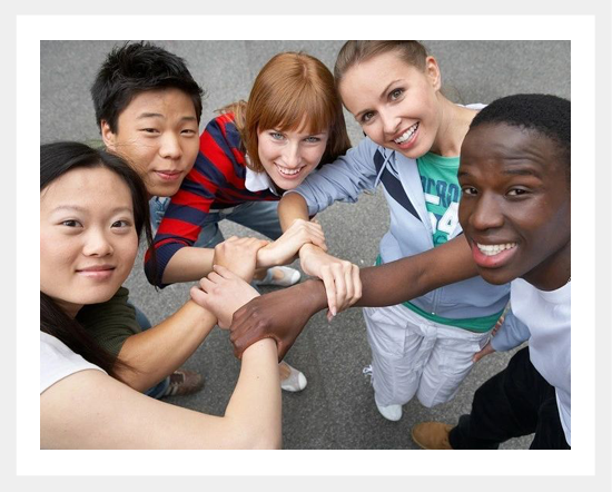 A group of people holding hands in the middle of a circle.