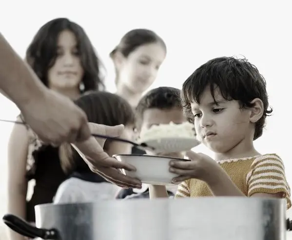 A group of people standing around eating food.